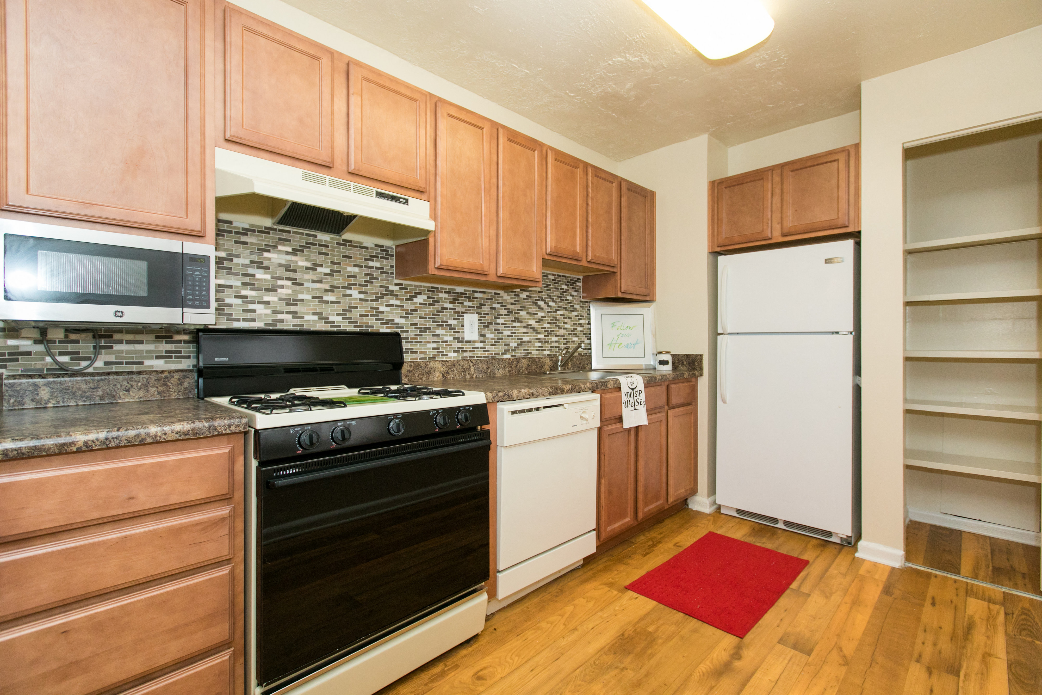 a kitchen with wooden cabinets and appliances and a white refrigerator