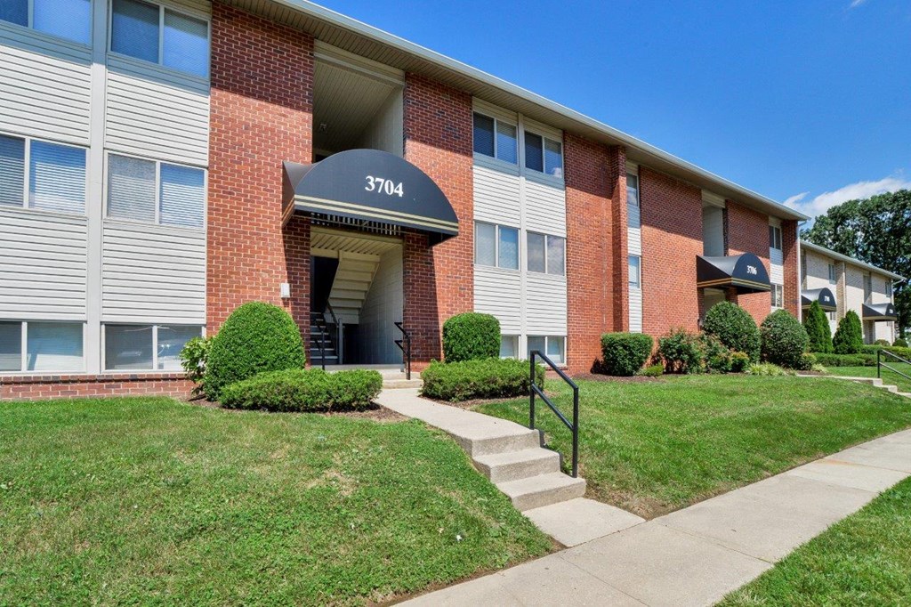 a brick building with a blue awning and stairs in front