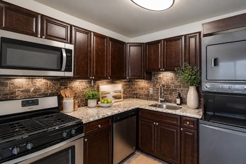 A kitchen with dark brown cabinets and a black stove top oven.