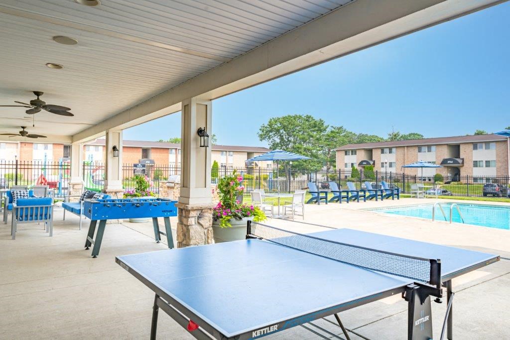 a ping pong table on a patio next to a pool