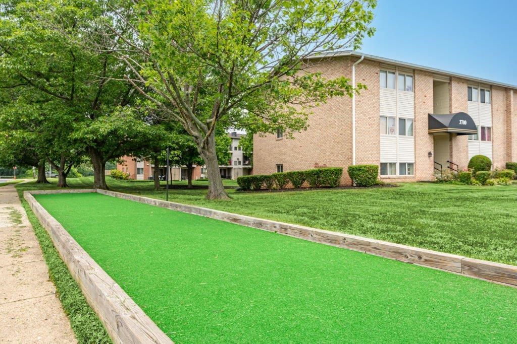 a green lawn in front of an apartment building
