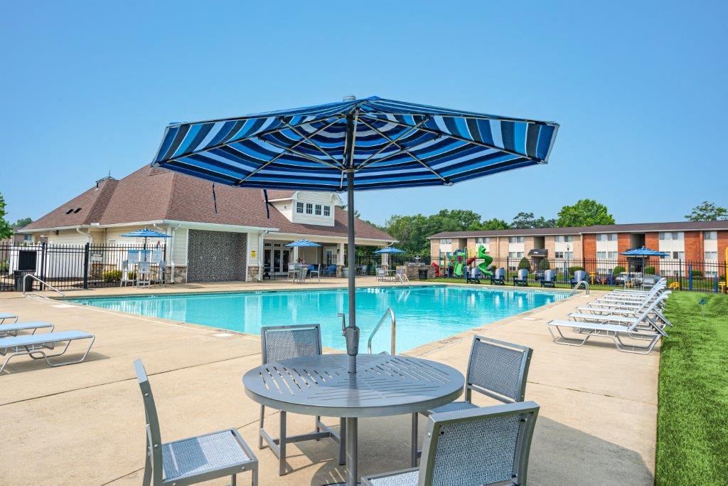 a swimming pool with tables and chairs and umbrellas
