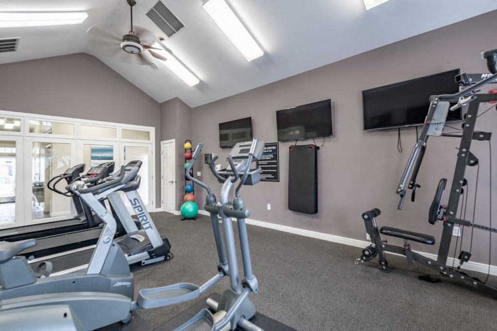 a gym with exercise equipment and a tv
