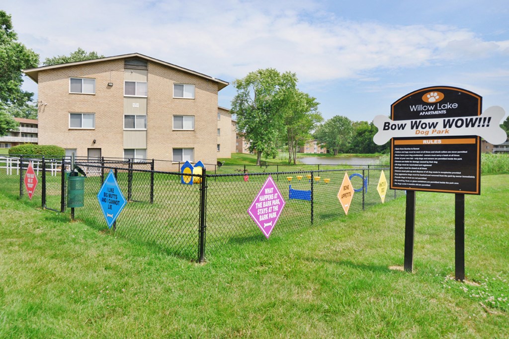a sign for bow wow wow in front of a fence with flags on it