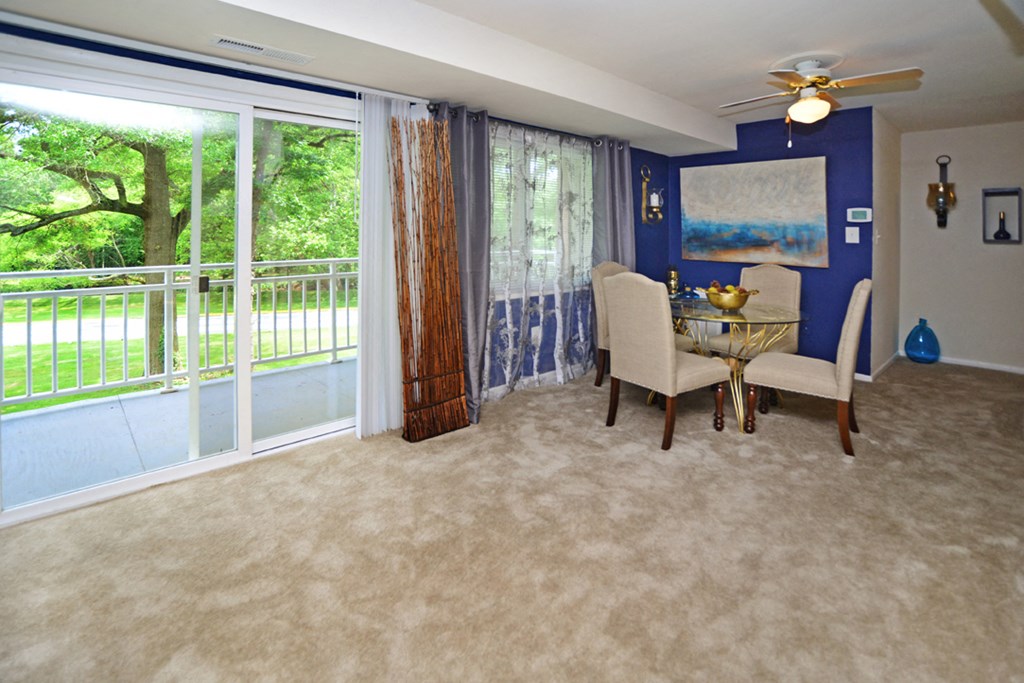 a dining room with a table and chairs and a sliding glass door
