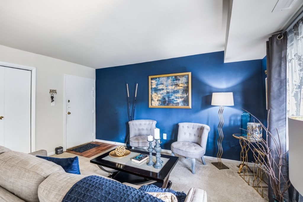 A living room with a grey sofa, a coffee table, and a blue wall.
