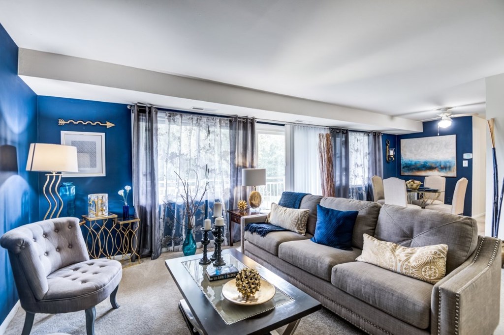 A living room with a grey couch, a chair, and a coffee table.