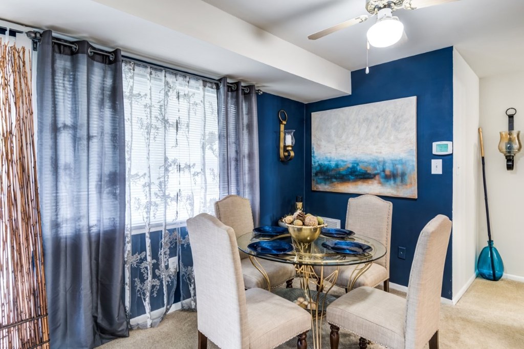 A dining room with a glass table and chairs.