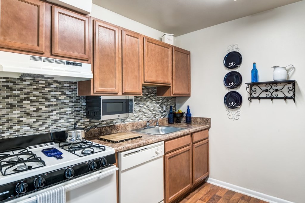 A kitchen with a white stove top oven and a microwave above the stove.