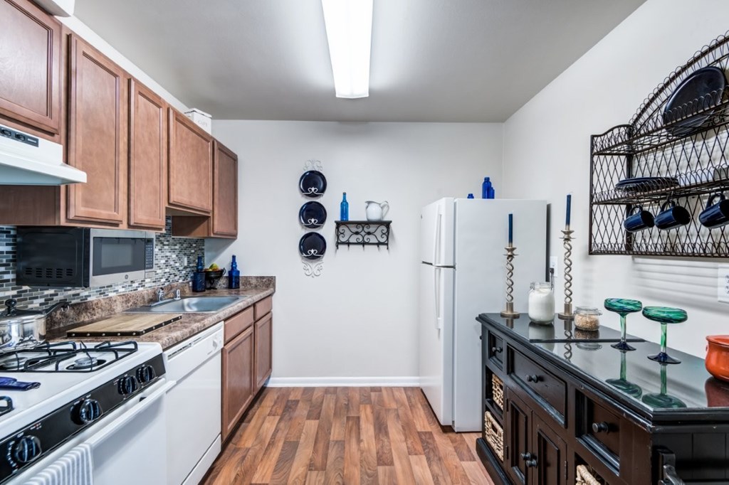 A kitchen with a white stove and a black counter.