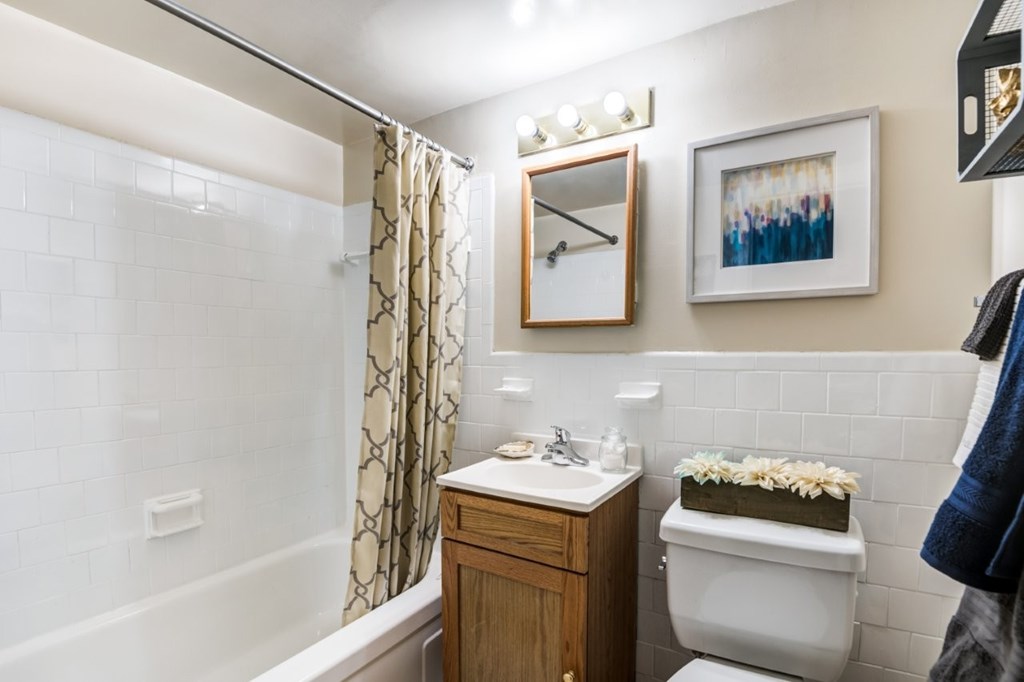 A bathroom with a toilet, sink, and a shower.