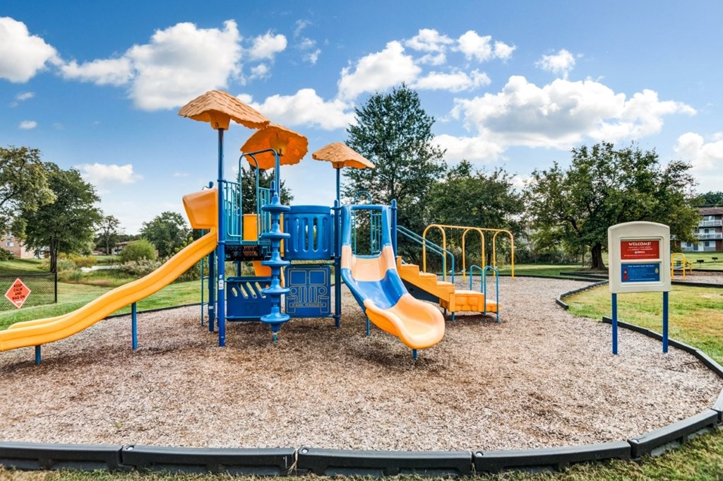 A playground with a blue and yellow slide and a yellow and blue climbing structure.