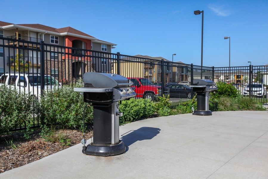 two benches on a sidewalk in front of a fence