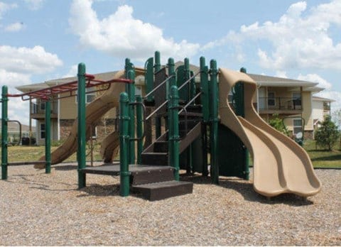 a playground with a slide in front of a house