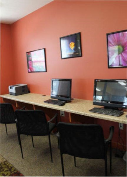 a desk with two computers and a laptop on it