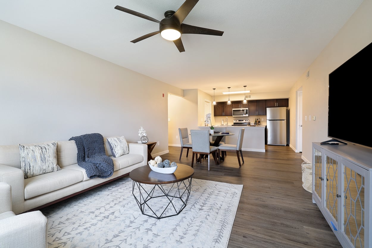 A living room with a white couch and a ceiling fan.