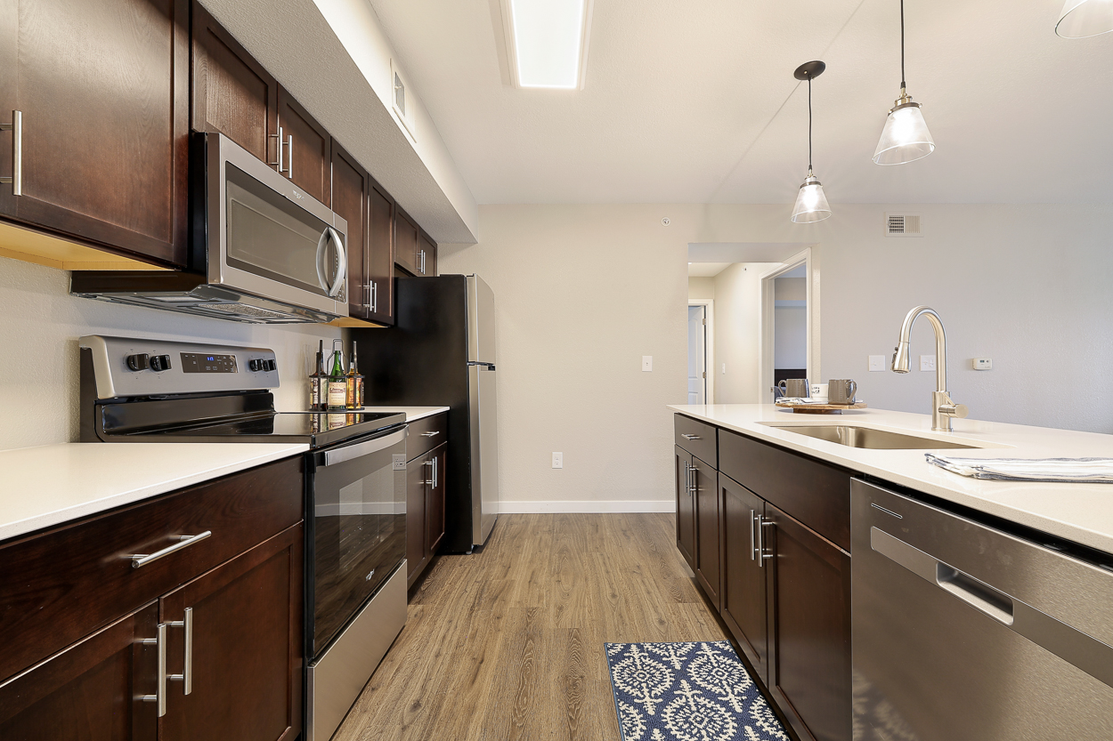 A kitchen with dark wood cabinets and stainless steel appliances.
