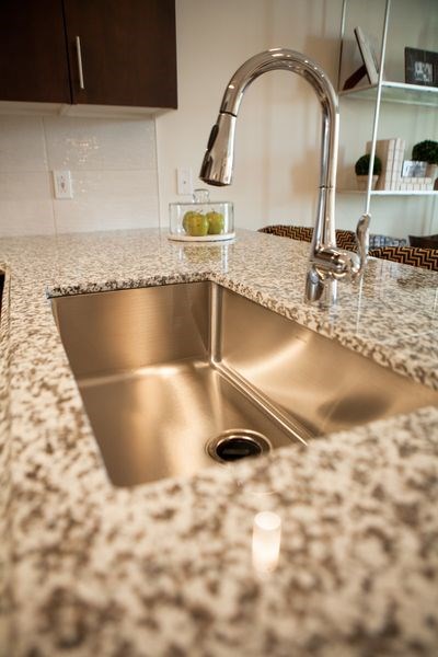 a stainless steel sink in a granite counter top