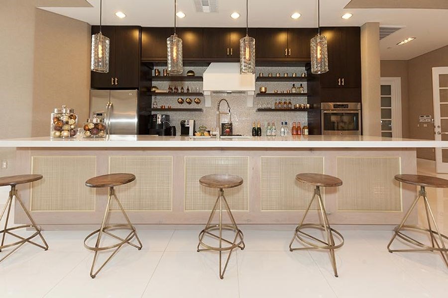a kitchen with bar stools and a counter