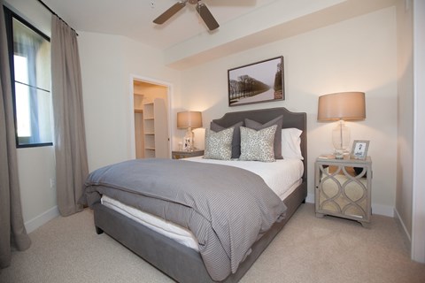 A bedroom with a large bed and a ceiling fan.