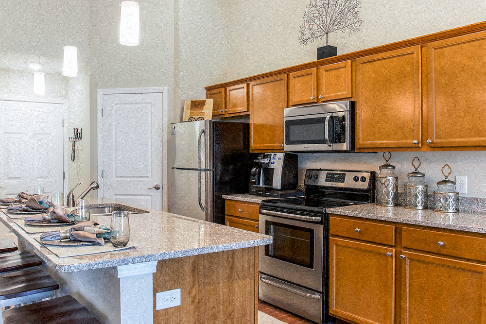 A kitchen with wooden cabinets and a granite countertop.