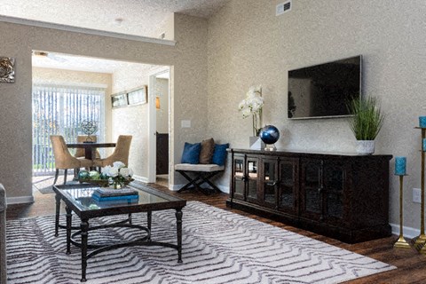 A living room with a black coffee table and a zebra rug.