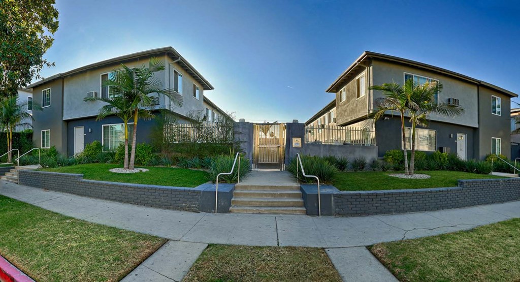 a street view of two houses with stairs and a sidewalk