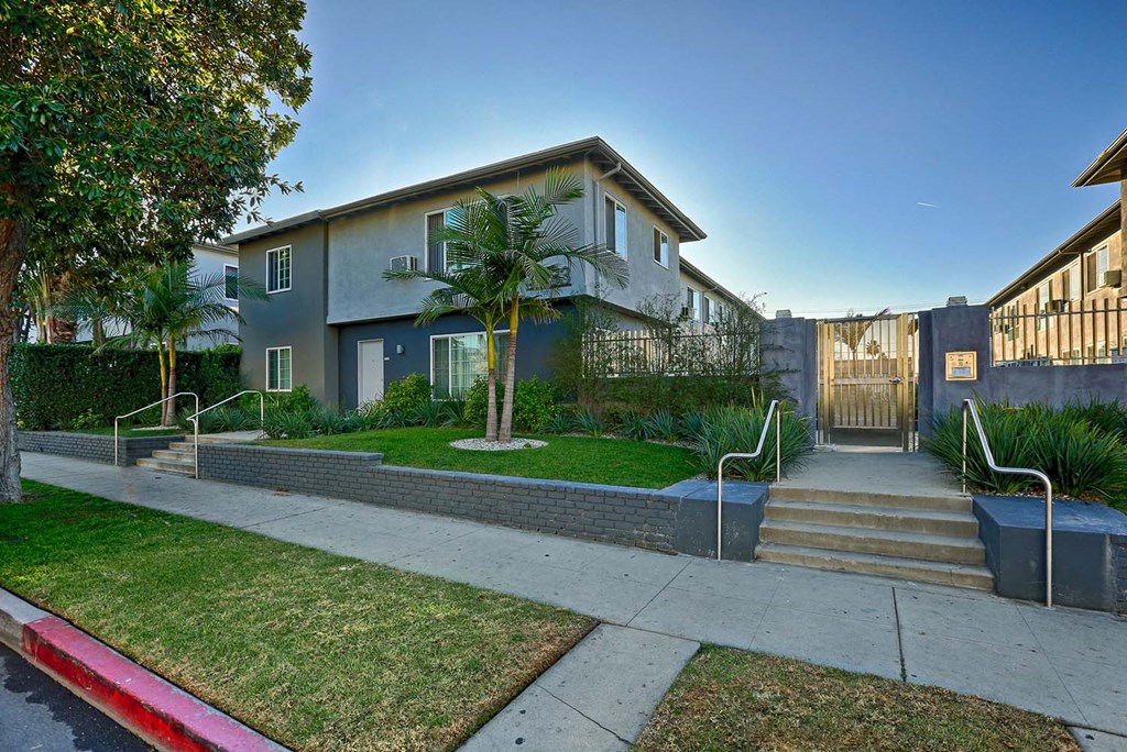 the front of a house with stairs and a sidewalk