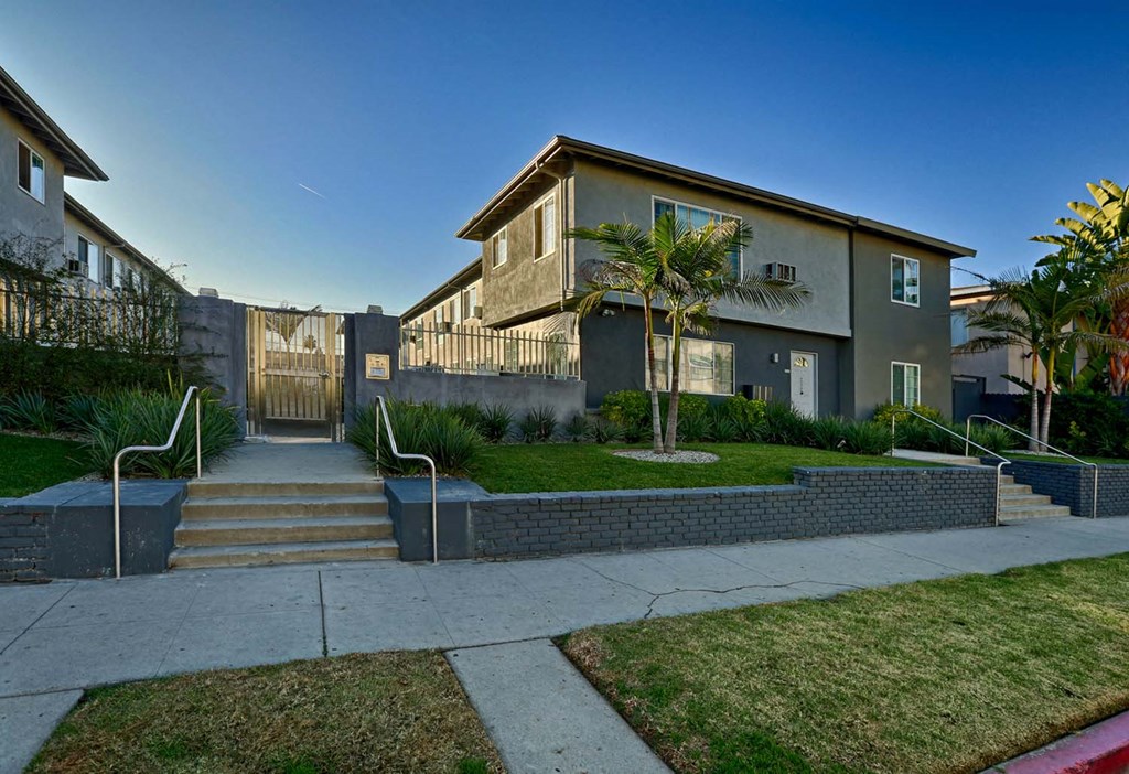 the front of a house with stairs and a sidewalk