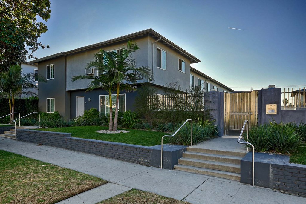 a house with stairs and a sidewalk in front of it