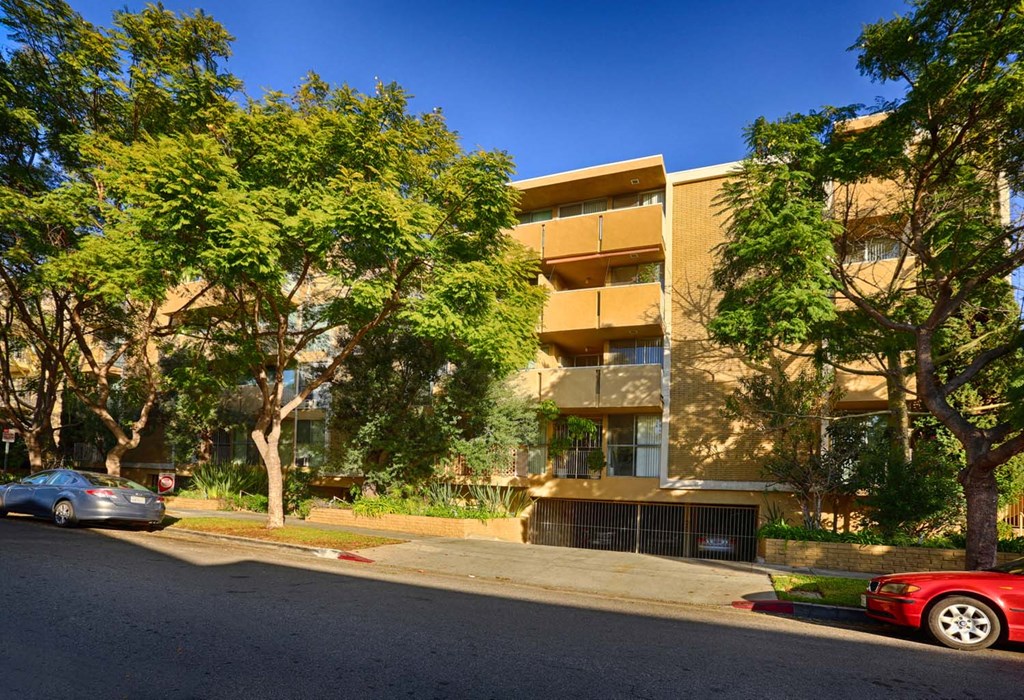 an apartment building with cars parked in front of it