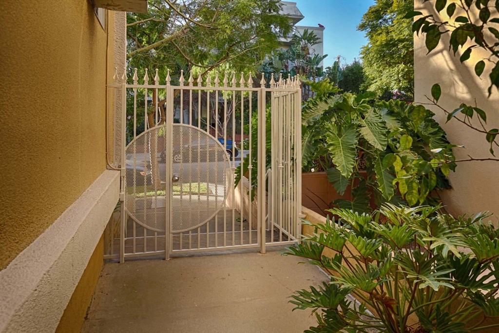a gate with a chair in a garden behind it