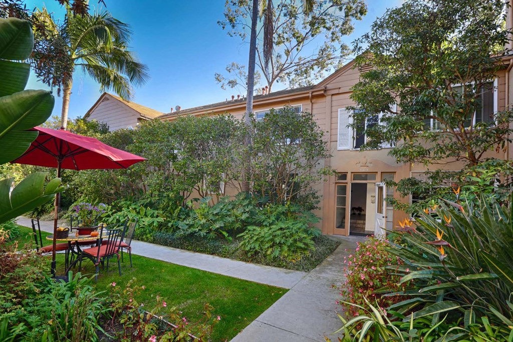 a patio with a table and chairs in front of a house