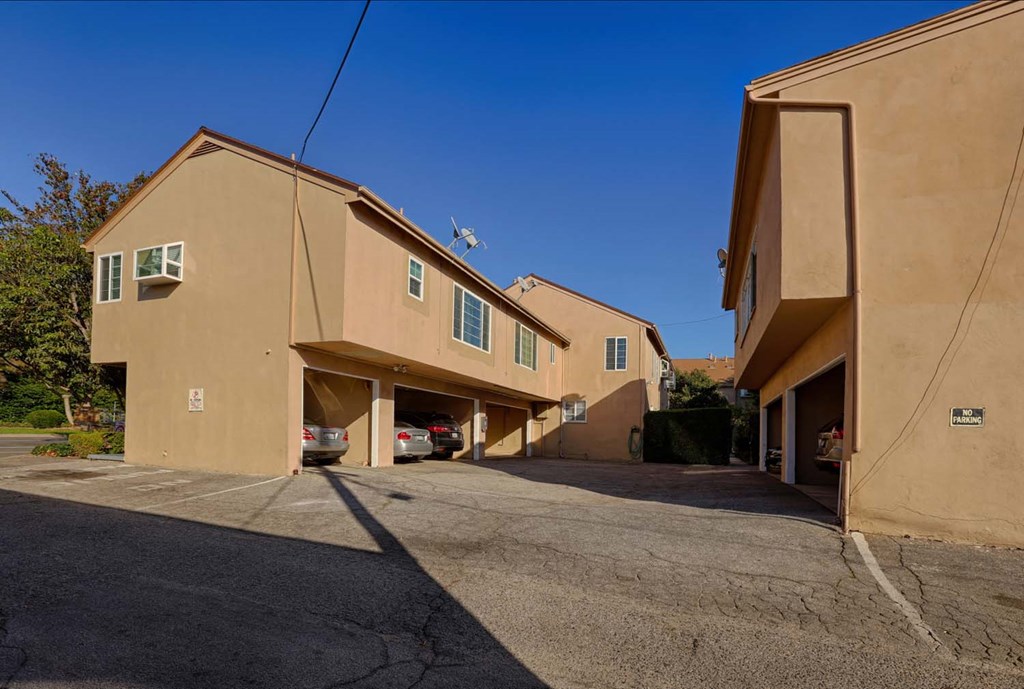 a row of buildings with cars parked in a parking lot