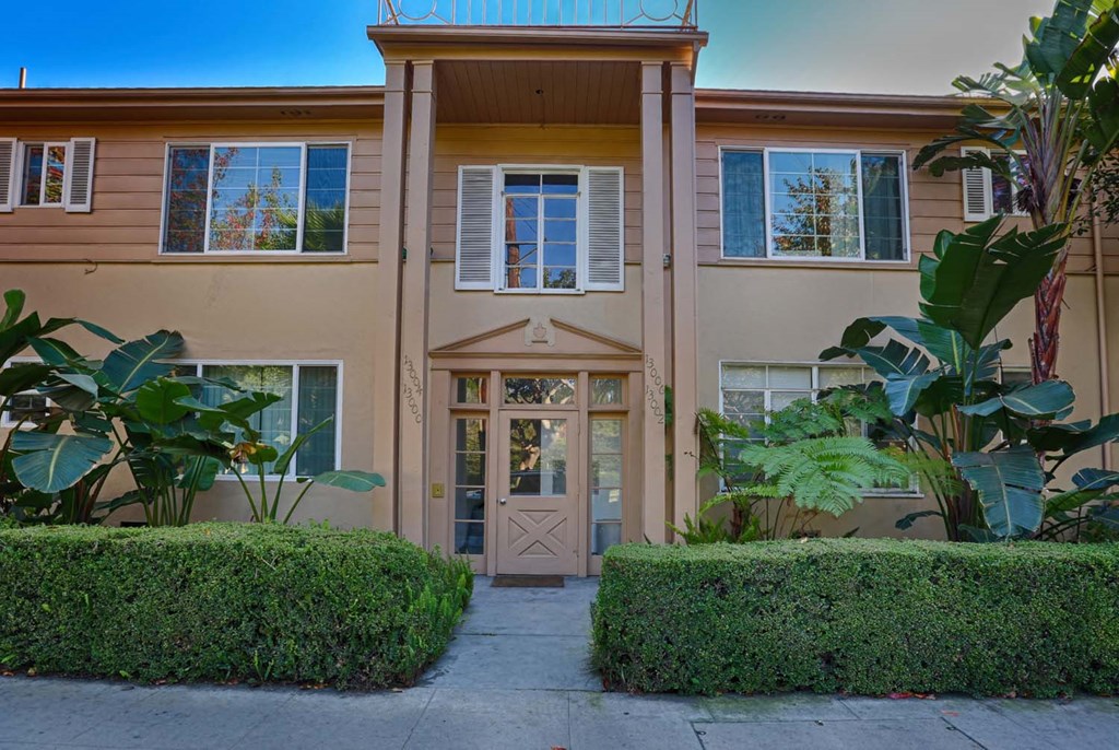the front of a building with a door and a sidewalk
