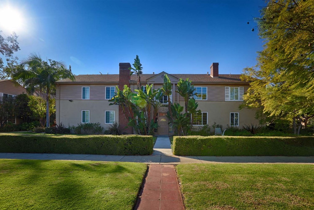 a large house with a sidewalk in front of it