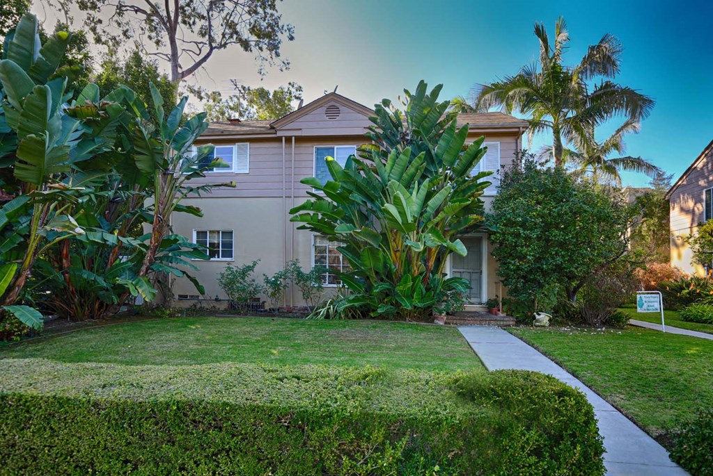 a house with a yard and a sidewalk in front of it