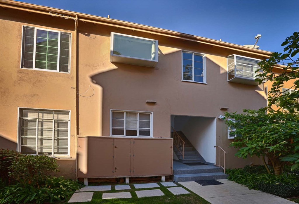 a side view of a house with a yard and stairs