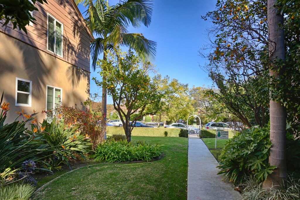 a path through a garden next to a building