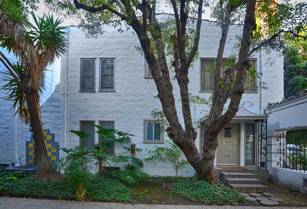 a white house with a tree in front of it