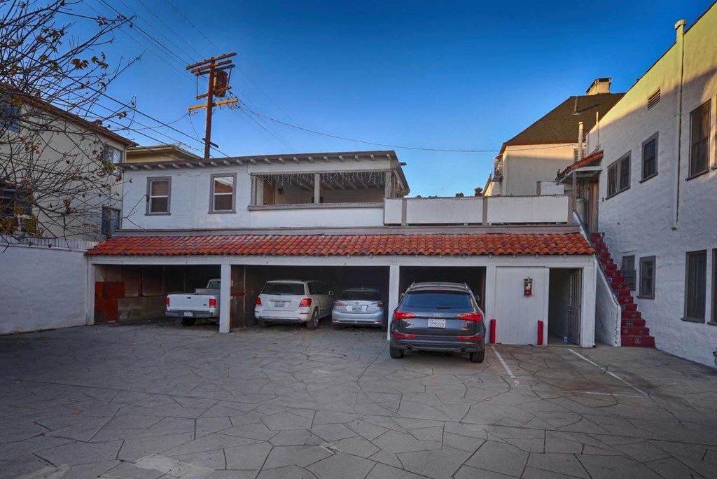 an empty parking lot with cars in front of a building