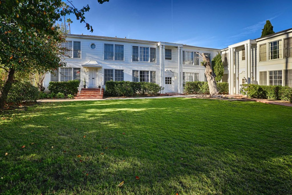 a large white house with a lawn in front of it