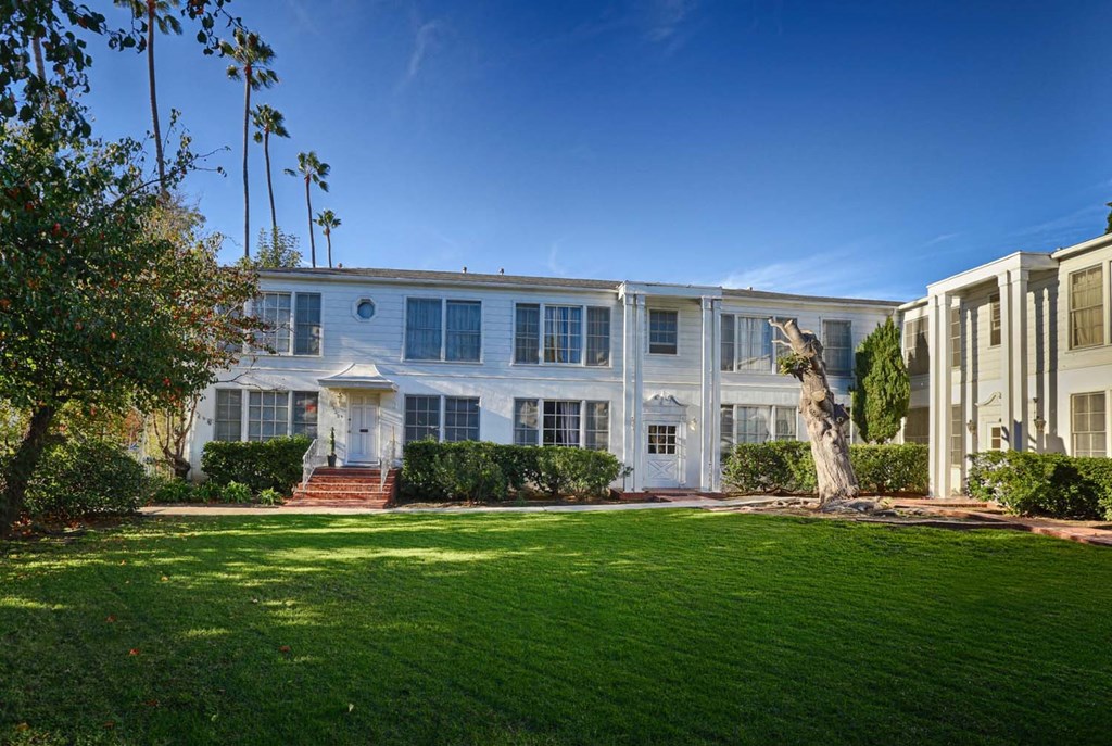 a white house with a green lawn in front of it