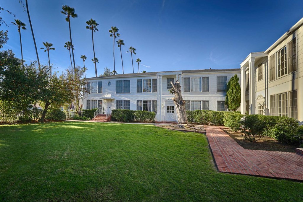 the home has a large lawn and a walkway in front of it