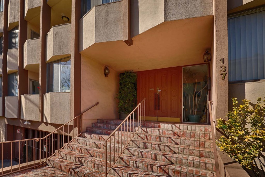the entrance to a building with stairs and a wooden door