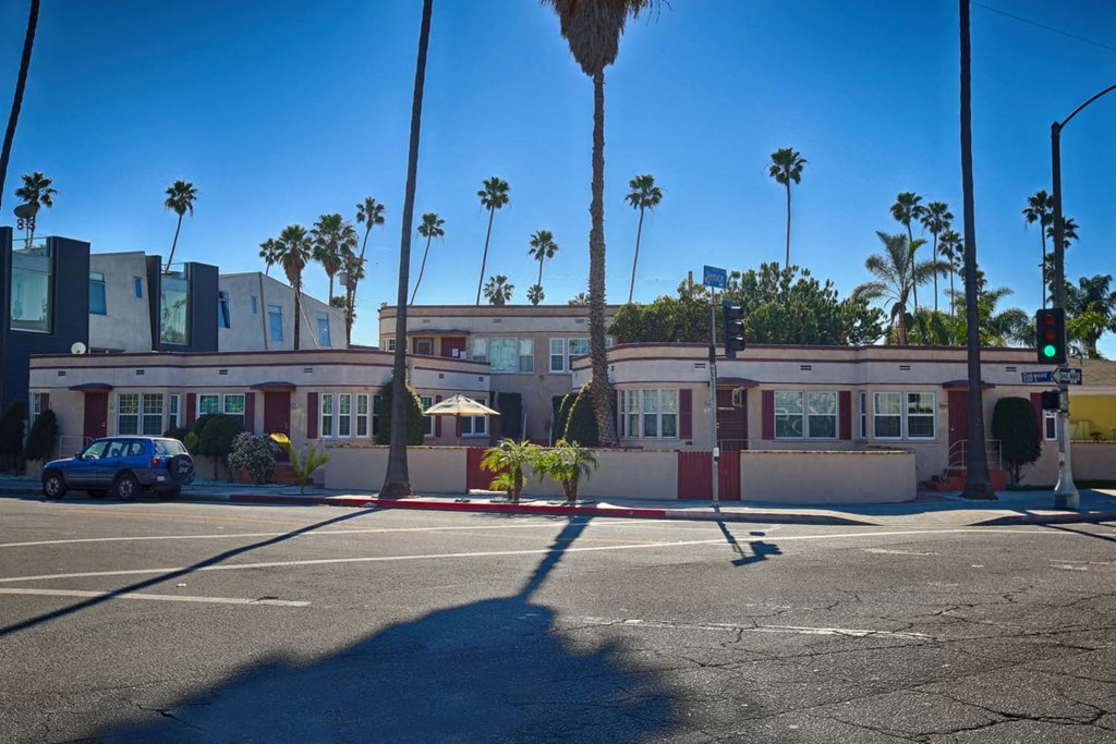 a building on a street corner with palm trees