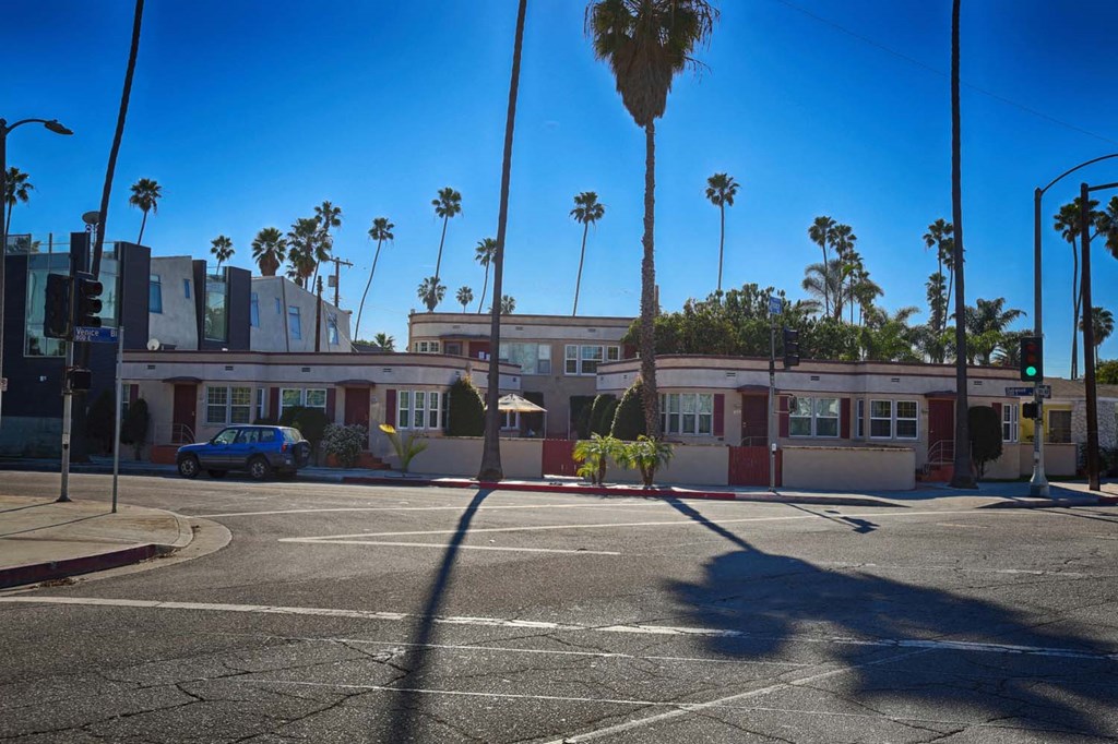 a building on a street corner with palm trees