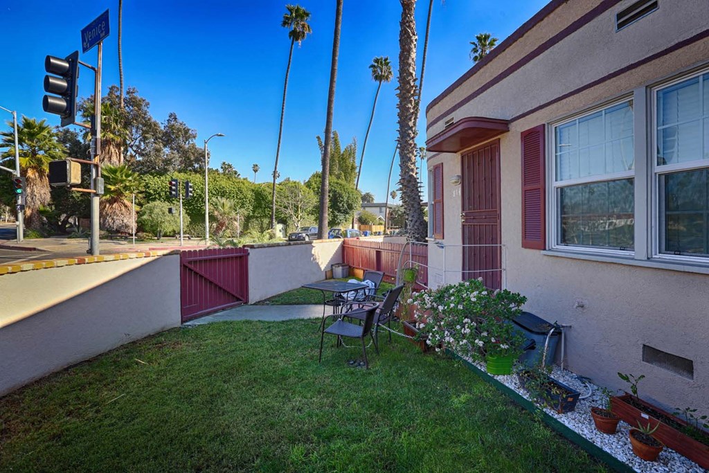 a backyard with a table and chairs outside of a house