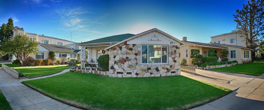 a home with a stone facade and green lawn