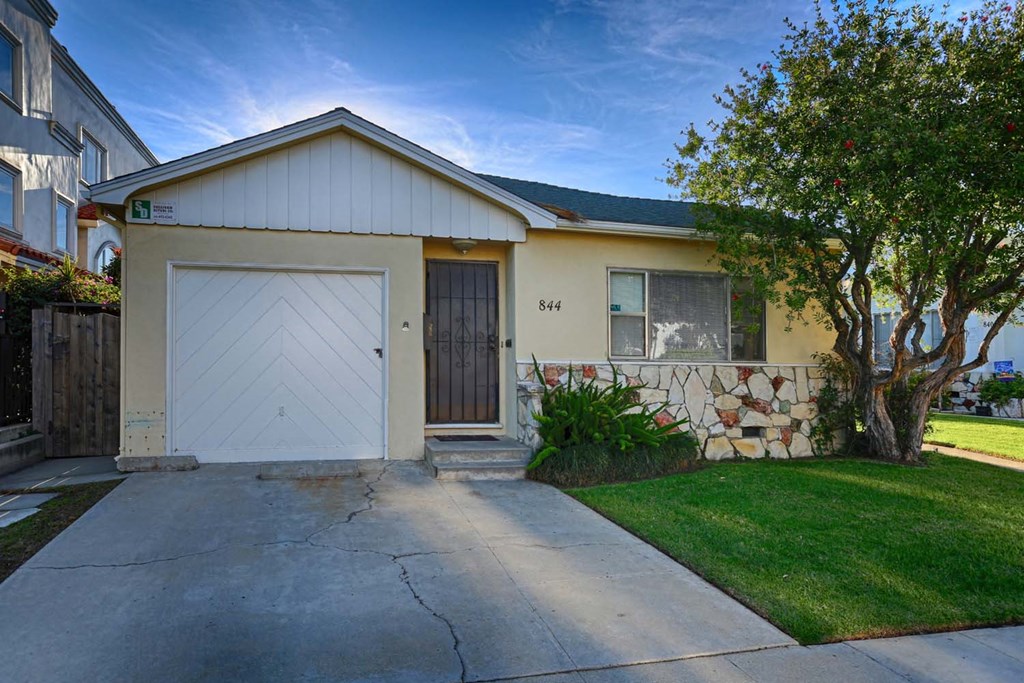 a white house with a white garage door and a driveway